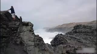 Guy Standing on top of Seaside Cliff With Pet Dog Gets Washed Over by Huge Wave - 1199140